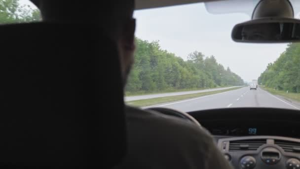 短髪の髭の男が街の外の高速道路に沿って車を運転している 髭を生やした男が休暇で家族を連れて行っている 高品質4K映像 — ストック動画