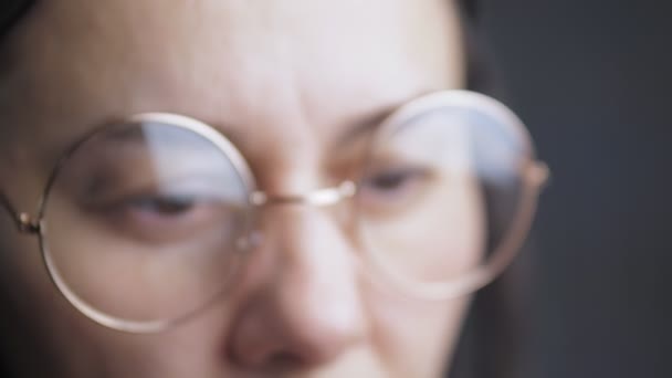 Een Blanke Vrouw Met Een Ronde Gouden Bril Kijkt Naar — Stockvideo