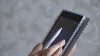 Kız tablete bir stil çiziyor. Kadınların elleri tabletle yakın plan çekimde. Kız çizim için gerekli rengi seçer. Yüksek kalite 4k görüntü