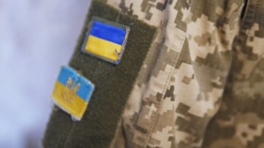 Üzerinde sarı ve mavi bir sembol olan askeri üniformalı bir adamın omuzları. Ukrayna ordusunun askeri, Ukrayna 'nın savunucusu. Yüksek kalite 4k görüntü