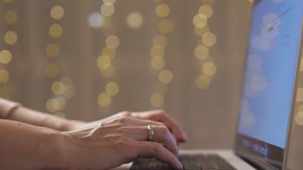 Zbliżenie Żeńskich Rąk Dziewczyna Pisze Laptopie Świąteczne Światła Migoczą Tle — Wideo stockowe