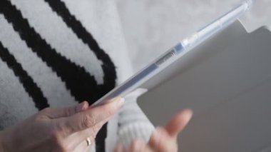 Elinde tablet tutan beyaz bir kadın var. 4K yakın çekim videosu. Yüksek kalite 4k görüntü