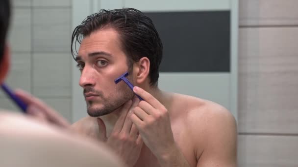 Όμορφος Άντρας Κοιτάζει Τον Καθρέφτη Και Ξυρίζεται Στο Μπάνιο — Αρχείο Βίντεο