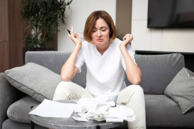 Masada oturan, faturalar ve faturalardan kaynaklanan masraflar yüzünden kafası karışık ve şaşkın kadının ev kredisi veya kredi ödeyecek parası yok. Yüksek fiyatlar ve harcama parası kavramı