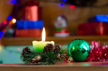 Noel Günü 'nde renkli dekorasyonlar arasında şenlik masasında parlayan mumların yakın plan fotoğrafı.