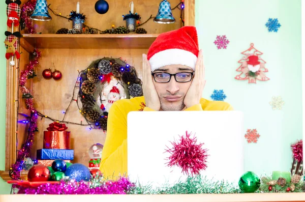 震惊的圣诞老人戴着圣诞老人的帽子 看着笔记本电脑 尽管圣诞节过得很愉快 — 图库照片