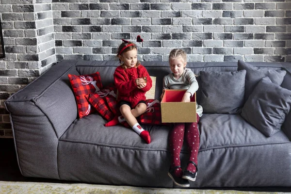 Két Kislány Kanapén Kinyitják Karácsonyi Ajándékot Egy Csodálatos Ünnepen — Stock Fotó