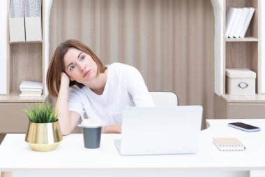 Genç bir kız öğrenci evdeki masada oturuyor ve yeni bir akademik yıla hazırlanıyor. Eğitim ve çevrimiçi eğitim kavramı