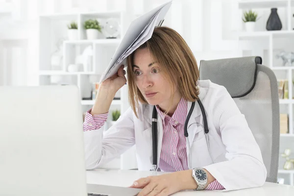 Tired female physician feeling bad after exhausted work day in the office of modern clinic