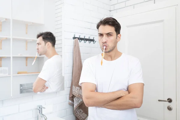 英俊的男人在浴室里刷牙摆姿势 — 图库照片