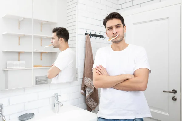 英俊的男人在浴室里刷牙摆姿势 — 图库照片