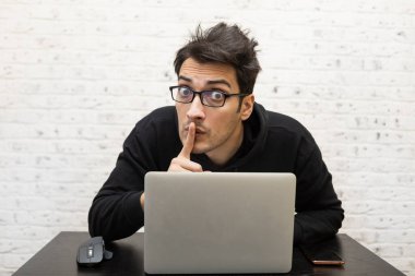 Yorgun ve sıkkın öğrenci üniversitede sınavlara hazırlanırken masada oturuyor.