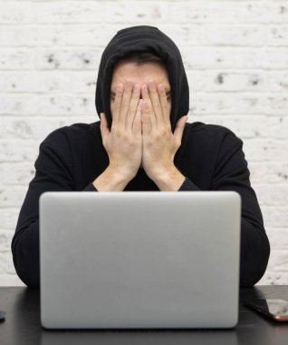 Yorgun ve sıkkın öğrenci üniversitede sınavlara hazırlanırken masada oturuyor.