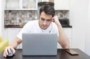 Yorgun ve sıkılmış bir adam üniversitede sınavlara hazırlanıyor.