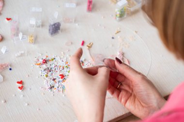 Yaratıcı bir kız boncuk işine girer. Hobi ve küçük işletme kavramı