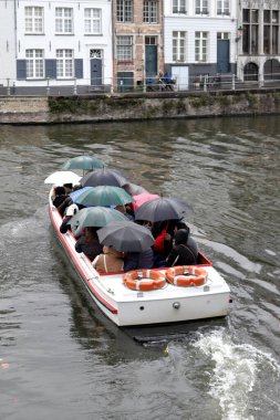 Sightseeing boat trip in canal on a rainy day in Bruges, Belgium