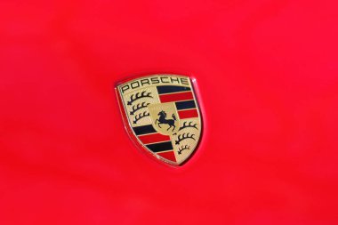 Londra, İngiltere - 9 Nisan 2023: Kırmızı bir arabanın ön tarafında bir Porsche logosu