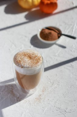 Beyaz masada tarçınlı latte, arka planda bulanık balkabağı. Yüksek kalite fotoğraf