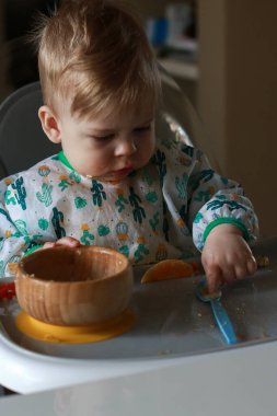 baby eating by himself learning through the Baby-led Weaning method, exploring the food 