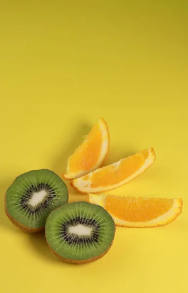 Primer Plano Kiwi Rodajas Naranja Sobre Fondo Amarillo Foto Alta — Foto de Stock