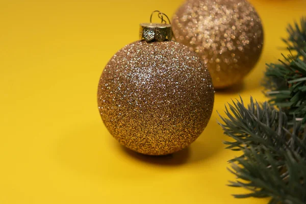 黄色背景的金色圣诞装饰球 绿色松树 复制空间 高质量的照片 — 图库照片