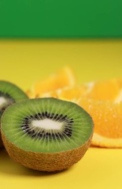 Sarı arka planda kivi ve portakal dilimlerini kapatın. Yüksek kalite fotoğraf