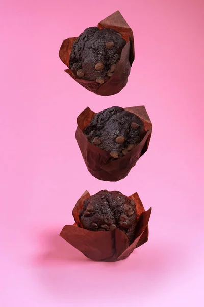 stock image levitation of chocolate chip muffins isolated on pink background . High quality photo