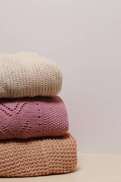 stack of folded knitwear, minimal lifestyle, capsule wardrobe, copy space. Cozy fall and winter wardrobe. High quality photo