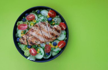 Siyah tabakta ızgara tavuk salatası, ballı hardal sosu, fotokopi alanı olan yeşil arka plan. Yüksek kalite fotoğraf