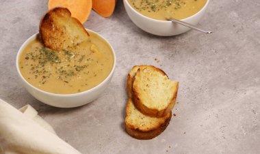 Beyaz kasede patates püresi çorbası ve gri mermer masada sarımsaklı ekmek. Yüksek kalite fotoğraf