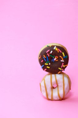 Verity mini donutları, jöleli ve pembe arka planda fotokopi alanı ile serpiştirilmiş. Yüksek kalite fotoğraf