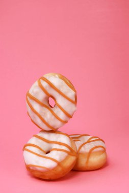 Verity mini donutları, jöleli ve pembe arka planda fotokopi alanı ile serpiştirilmiş. Yüksek kalite fotoğraf