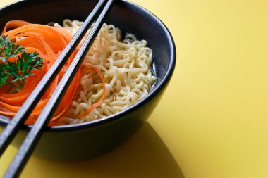 Sarı arka planda çubuklu vejetaryen ramen eriştesi. Yüksek kalite fotoğraf