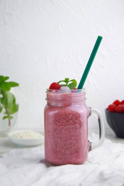 Ketogenic ahududu smoothie 'yi yeniden kullanılabilir saman, ahududu ve nane içeren bir kavanozda buzla kapatın. kopyalama alanı. Yüksek kalite fotoğraf