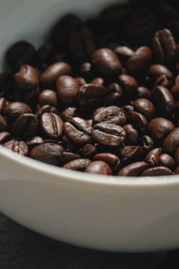 Kahve çekirdeklerini beyaz bir kaseye koy. Yüksek kalite fotoğraf