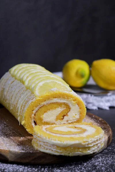 stock image delicious vanilla cake roll with lemon butter cream inside, dark grey marble table and copy space