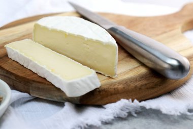 Brie peynirini ahşap tabakta kapat, kopyalama alanı olan beyaz arkaplan 