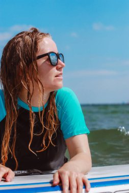 Genç ve güzel bir kadın denizde yemek yerken gülüp eğleniyor. Sağlıklı ve hayat dolu..