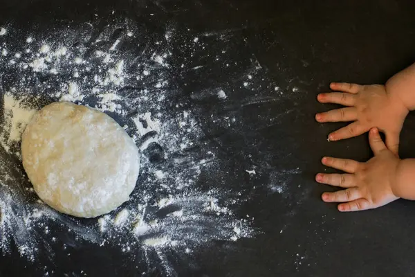 Pizza hamuru için yükselen mayanın üst görüntüsü ya da yeni yürümeye başlayan ellerle ekmek, gri mermer masa