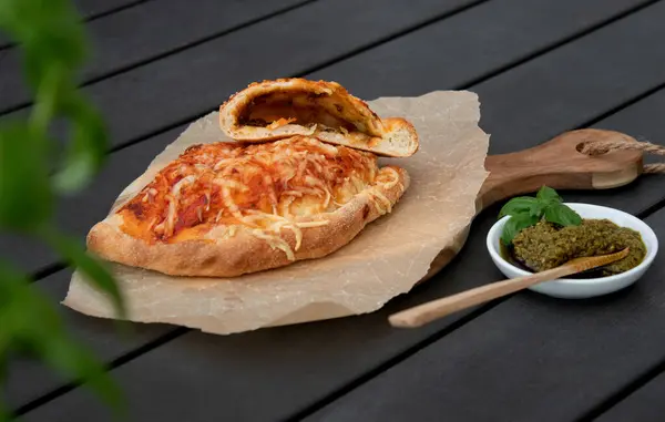Вкусная Пицца Кальцоне Томатным Соусом Сыром Деревянной Тарелке Серый Стол — стоковое фото