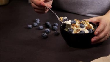 Kadınların elleri siyah kasede taze yaban mersinli süzme peynir karıştırırken, protein tatlısıyla savaşırken.