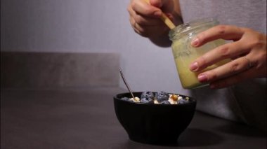 Siyah kasede yabanmersini ve cevizli süzme peynire bal koyan kadına yaklaş, protein tatlısıyla savaş.