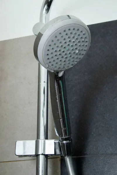 Close up of a dirt shower head in a shower cabin at home