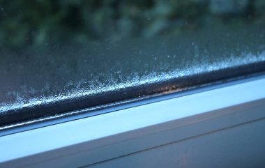 Penceredeki buharlaşmayı kapat. Su damlaları ve nem oranı, bulanık arkaplan.