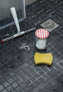 Kabartma tozu, sünger ve fayans duş zemininde duş bezi, çevre dostu temizlik konsepti.