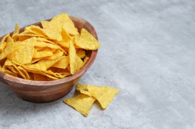 Tahta bir kasede tuzlu tortilla. Fotokopi alanı olan gri mermer masa..