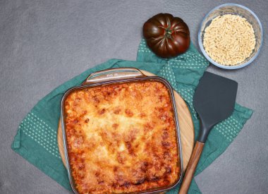 Ev yapımı vejetaryen lazanya, soya eti ve vejetaryen peyniri gri masada.