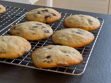 Mutfak masasındaki fırın rafında taze çikolatalı kurabiyeleri kapat, fırınlı bulanık arka plan.