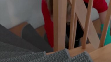 Kafkasyalı bir kadının evdeki tahta merdivenleri silişi.