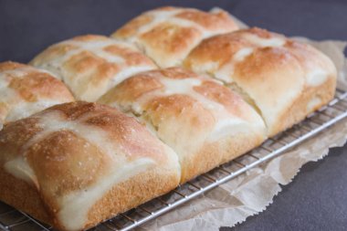 Fırında pişmiş sıcak haç çörekleri fırında, gri mutfak masasında. 